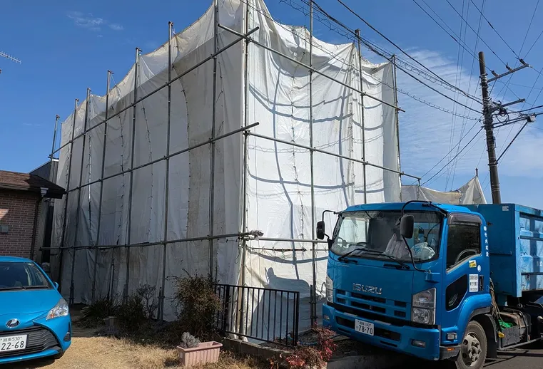 粉じん飛散防止のために防音シートで囲われた建物